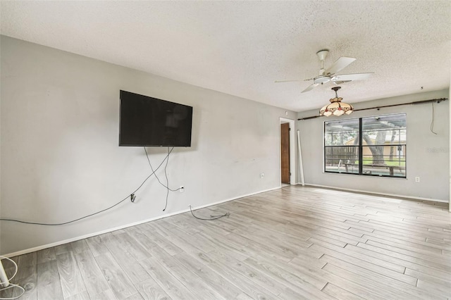 2410 Covington Ave, Spring Hill, FL 34608 - unfurnished living room with a textured ceiling, a ceiling fan, wood finished floors, and baseboards