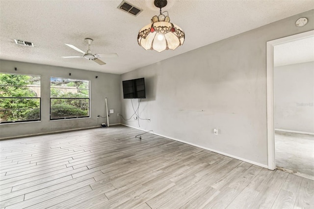 2410 Covington Ave, Spring Hill, FL 34608 - spare room with wood finished floors, ceiling fan, a textured ceiling, and baseboards