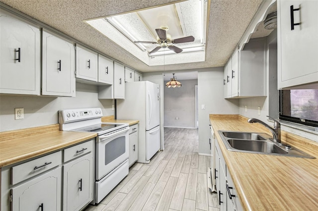 2410 Covington Ave, Spring Hill, FL 34608 - kitchen featuring white appliances, a sink, a ceiling fan, baseboards, and light wood-style flooring
