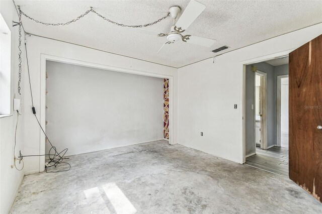 2410 Covington Ave, Spring Hill, FL 34608 - unfurnished room with unfinished concrete flooring, ceiling fan, and a textured ceiling