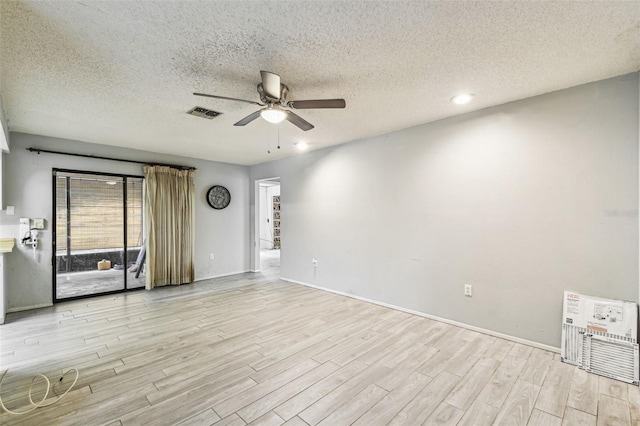 2410 Covington Ave, Spring Hill, FL 34608 - spare room with light wood finished floors, a ceiling fan, a textured ceiling, and baseboards