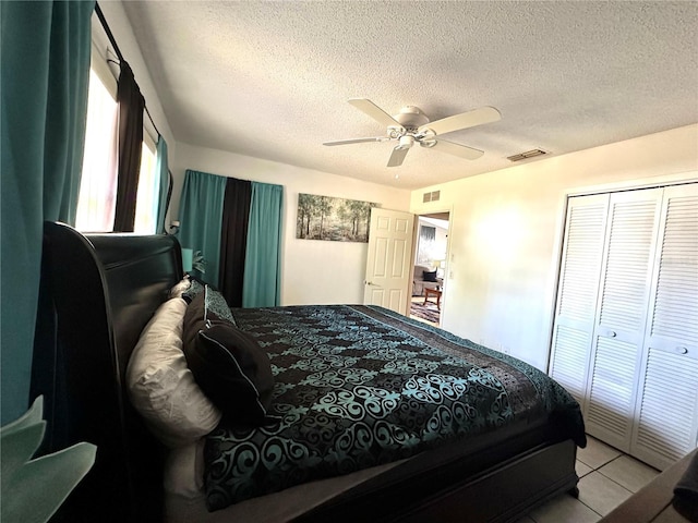 13100 Serpentine Dr, Hudson, FL 34667 - bedroom with a textured ceiling, tile patterned flooring, a closet, and a ceiling fan