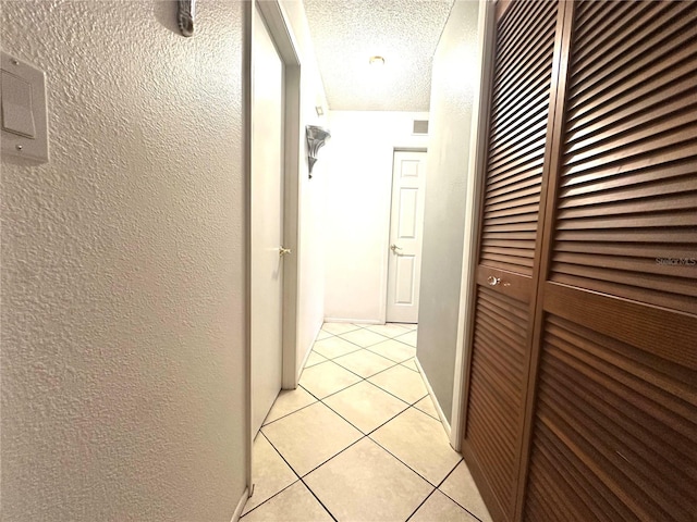 13100 Serpentine Dr, Hudson, FL 34667 - hall with a textured ceiling, light tile patterned flooring, and a textured wall