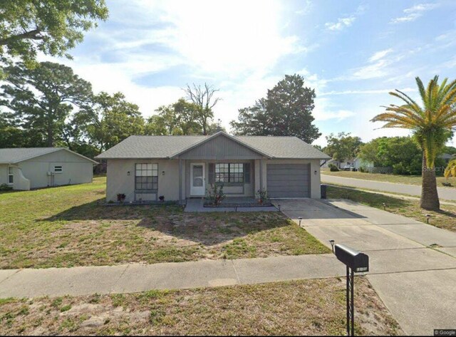 13100 Serpentine Dr, Hudson, FL 34667 - view of front of house featuring an attached garage, concrete driveway, and a front yard