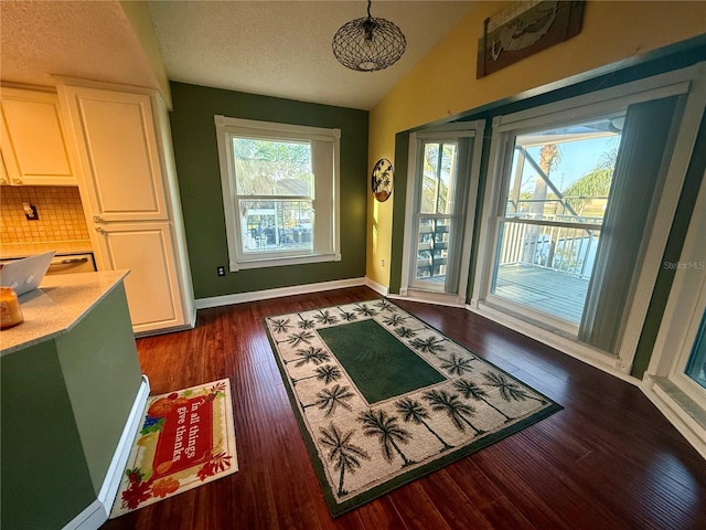 3338 Fernleaf Dr, Hernando Beach, FL 34607 - dining room with dark wood finished floors, vaulted ceiling, baseboards, and a textured ceiling