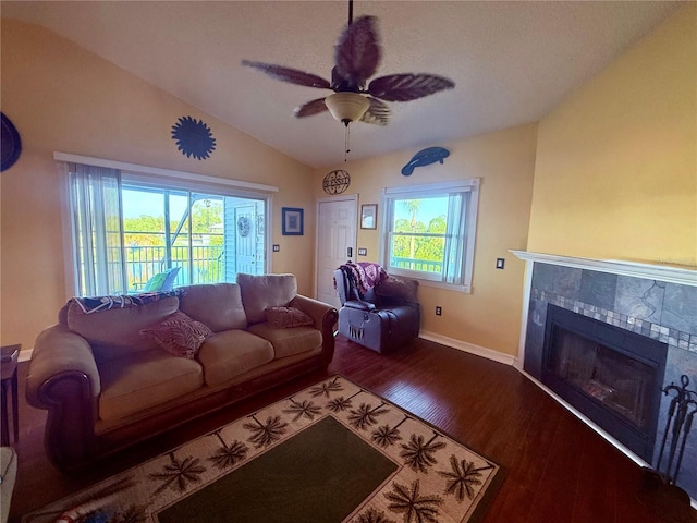 3338 Fernleaf Dr, Hernando Beach, FL 34607 - living room featuring lofted ceiling, baseboards, ceiling fan, a tile fireplace, and wood finished floors