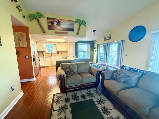 3338 Fernleaf Dr, Hernando Beach, FL 34607 - living area featuring light wood-type flooring, baseboards, and vaulted ceiling