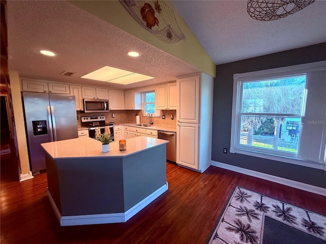 3338 Fernleaf Dr, Hernando Beach, FL 34607 - kitchen featuring appliances with stainless steel finishes, a textured ceiling, a sink, white cabinetry, and dark wood-type flooring