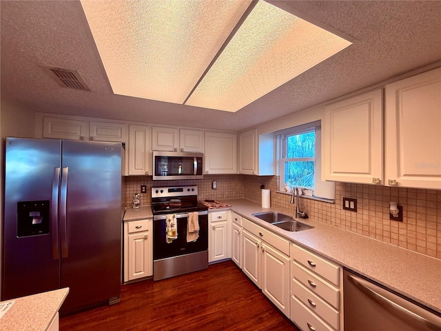 3338 Fernleaf Dr, Hernando Beach, FL 34607 - kitchen featuring appliances with stainless steel finishes, a sink, dark wood-style flooring, light countertops, and a textured ceiling