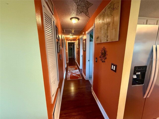 3338 Fernleaf Dr, Hernando Beach, FL 34607 - hallway with a textured ceiling, dark wood-style floors, and baseboards
