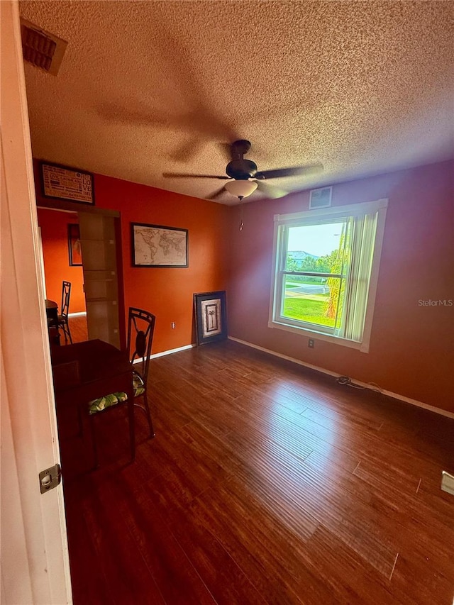 3338 Fernleaf Dr, Hernando Beach, FL 34607 - unfurnished room with wood finished floors, a textured ceiling, a ceiling fan, and baseboards