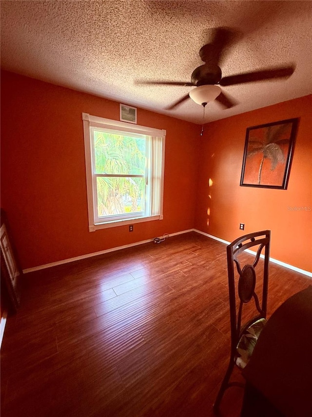 3338 Fernleaf Dr, Hernando Beach, FL 34607 - spare room featuring a textured ceiling, wood finished floors, a ceiling fan, and baseboards