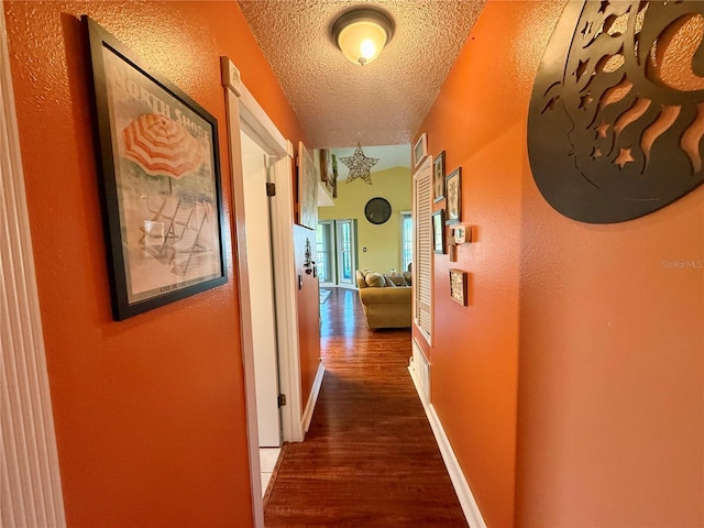 3338 Fernleaf Dr, Hernando Beach, FL 34607 - hall with wood finished floors, a textured ceiling, a textured wall, and baseboards