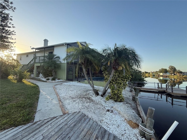 3338 Fernleaf Dr, Hernando Beach, FL 34607 - back of house at dusk featuring stairs and a water view