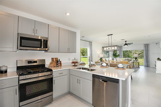 12435 Gust Ct, Hudson, FL 34669 - kitchen with stainless steel appliances, a sink, gray cabinetry, light countertops, and recessed lighting
