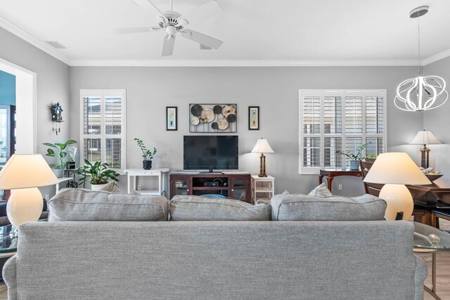 1110 Jasmine Creek Ct, Sun City Center, FL 33573 - living area featuring a chandelier, crown molding, a ceiling fan, and wood finished floors