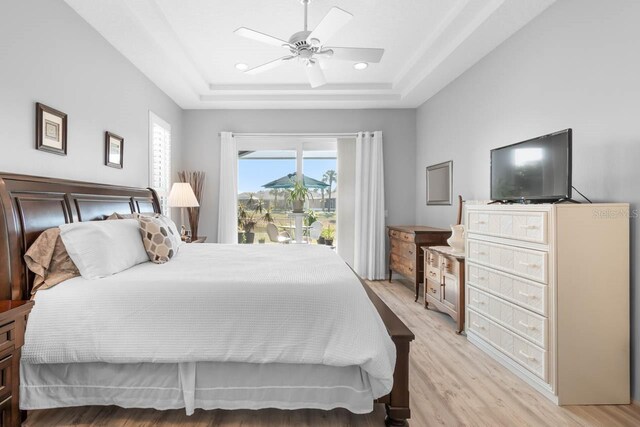 1110 Jasmine Creek Ct, Sun City Center, FL 33573 - bedroom with a tray ceiling, light wood-style floors, access to exterior, a ceiling fan, and recessed lighting