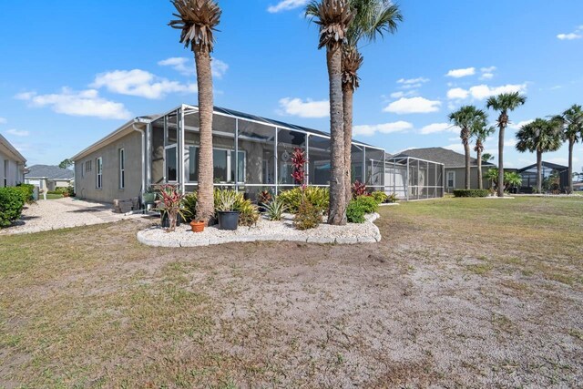 1110 Jasmine Creek Ct, Sun City Center, FL 33573 - rear view of property with glass enclosure and a lawn