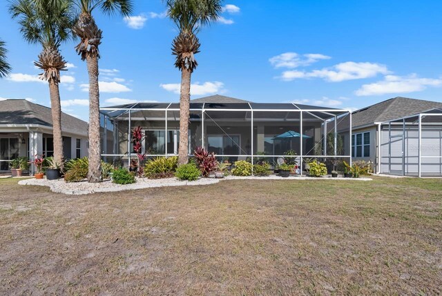 1110 Jasmine Creek Ct, Sun City Center, FL 33573 - rear view of house with a yard and glass enclosure