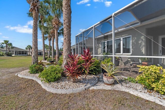 1110 Jasmine Creek Ct, Sun City Center, FL 33573 - view of green lawn with glass enclosure and a patio area
