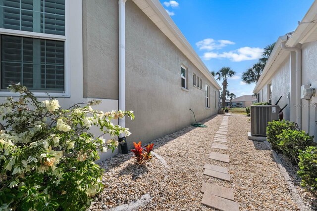 1110 Jasmine Creek Ct, Sun City Center, FL 33573 - view of side of property featuring central AC unit and stucco siding