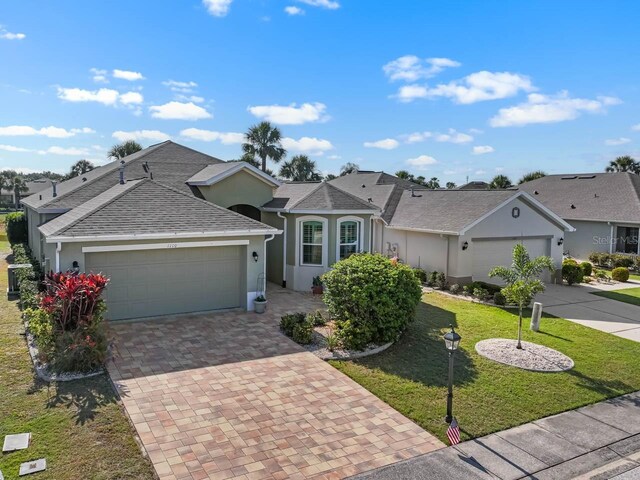 1110 Jasmine Creek Ct, Sun City Center, FL 33573 - single story home with a garage, stucco siding, decorative driveway, a front lawn, and roof with shingles