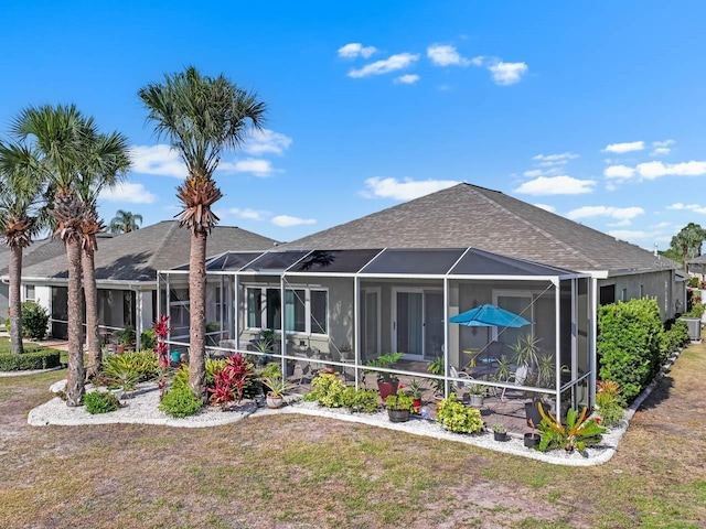 1110 Jasmine Creek Ct, Sun City Center, FL 33573 - rear view of property featuring a shingled roof, a lawn, and a patio area