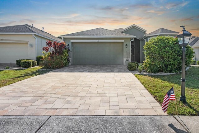 1110 Jasmine Creek Ct, Sun City Center, FL 33573 - ranch-style house featuring decorative driveway, an attached garage, and stucco siding
