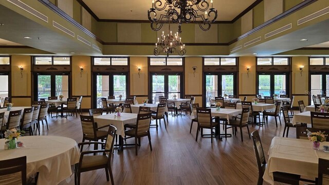 1110 Jasmine Creek Ct, Sun City Center, FL 33573 - dining space with a towering ceiling, wood finished floors, plenty of natural light, french doors, and ornamental molding