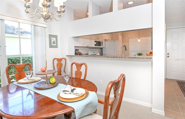 14840 Shipwatch Trce Unit 1924, Largo, FL 33774 - dining area featuring a chandelier, a textured ceiling, baseboards, and light colored carpet
