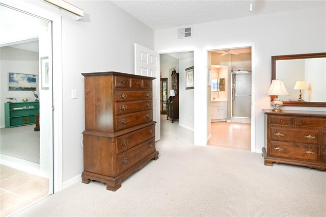 14840 Shipwatch Trce Unit 1924, Largo, FL 33774 - bedroom featuring light colored carpet, baseboards, light tile patterned floors, and ensuite bath