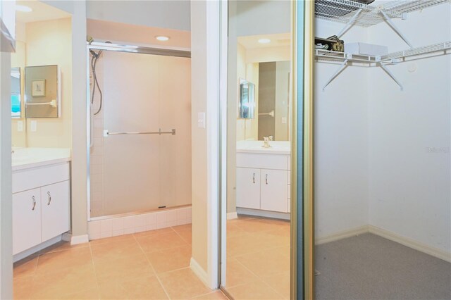 14840 Shipwatch Trce Unit 1924, Largo, FL 33774 - full bath featuring a stall shower, vanity, tile patterned flooring, baseboards, and a walk in closet