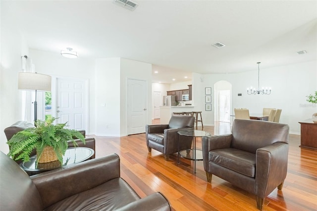 20403 Sultana Ct, Tampa, FL 33647 - living area featuring arched walkways, a chandelier, light wood-type flooring, baseboards, and recessed lighting