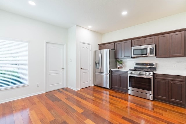 20403 Sultana Ct, Tampa, FL 33647 - kitchen featuring stainless steel appliances, light countertops, wood finished floors, dark brown cabinetry, and baseboards