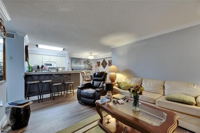 9481 Highland Oak Dr Unit 1511, Tampa, FL 33647 - living room featuring wood finished floors, a textured ceiling, and crown molding