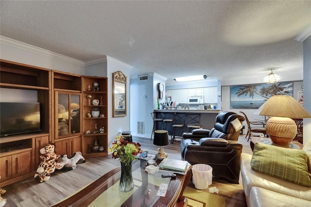9481 Highland Oak Dr Unit 1511, Tampa, FL 33647 - living room featuring wood finished floors, crown molding, a textured ceiling, and a chandelier