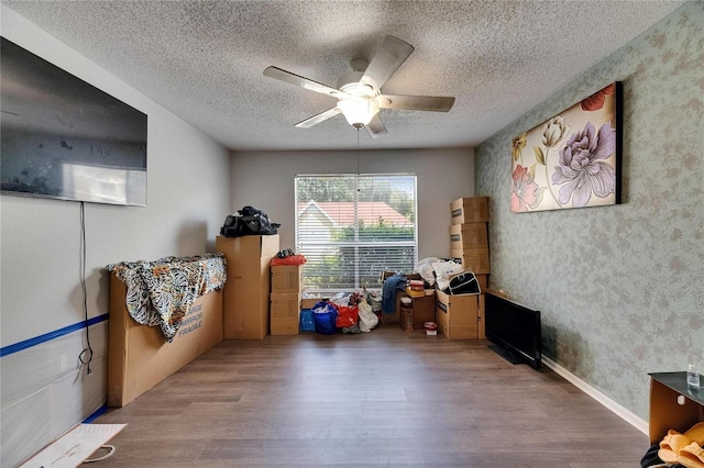 9481 Highland Oak Dr Unit 1511, Tampa, FL 33647 - recreation room featuring wood finished floors, ceiling fan, a textured ceiling, and wallpapered walls