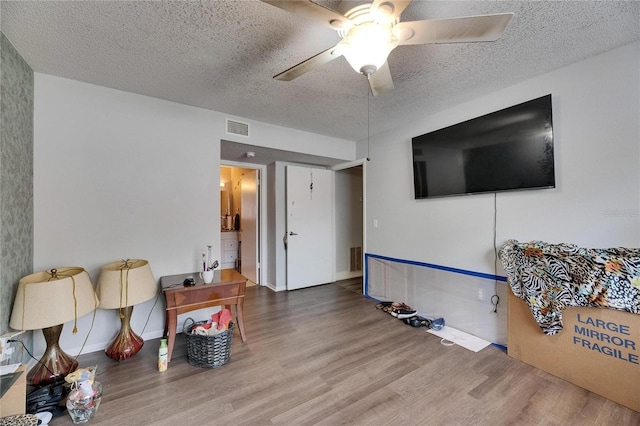 9481 Highland Oak Dr Unit 1511, Tampa, FL 33647 - living area featuring a textured ceiling, wood finished floors, and ceiling fan