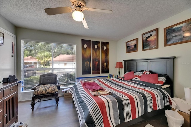 9481 Highland Oak Dr Unit 1511, Tampa, FL 33647 - bedroom featuring a textured ceiling, multiple windows, wood finished floors, and a ceiling fan