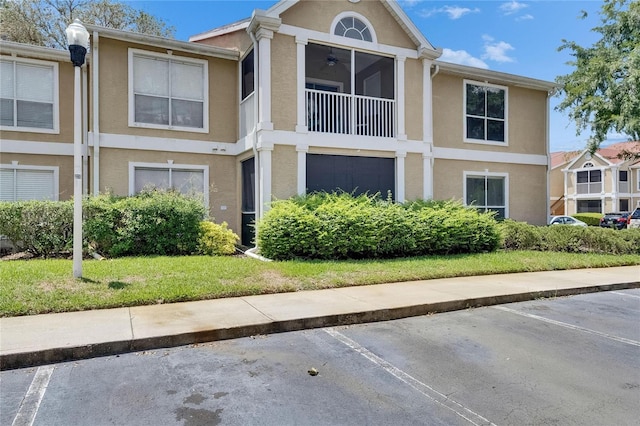 9481 Highland Oak Dr Unit 1511, Tampa, FL 33647 - view of side of property featuring stucco siding, uncovered parking, and a ceiling fan