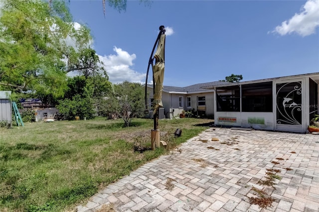 1242 Bermuda St, Clearwater, FL 33755 - view of green lawn with a sunroom and a patio area