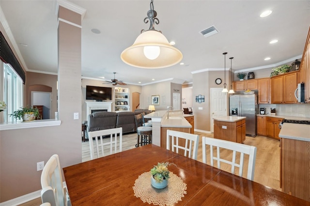 5704 Eaglemount Cir, Lithia, FL 33547 - dining room featuring ceiling fan, crown molding, light wood-style flooring, a fireplace, and recessed lighting
