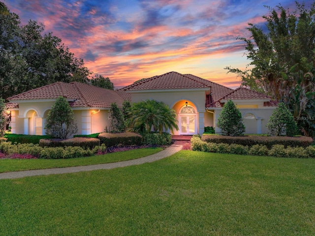 10504 Echo Lake Dr, Odessa, FL 33556 - mediterranean / spanish house featuring french doors, a yard, stucco siding, and a tiled roof