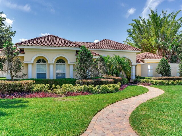 10504 Echo Lake Dr, Odessa, FL 33556 - mediterranean / spanish-style house with a front lawn, a tile roof, and stucco siding