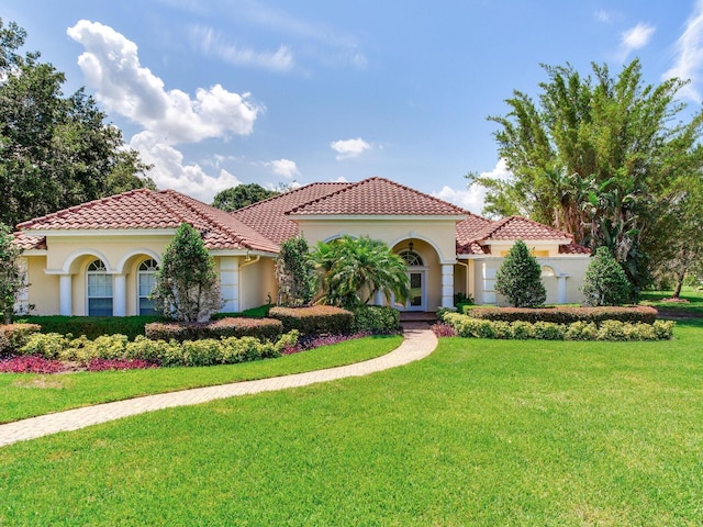 10504 Echo Lake Dr, Odessa, FL 33556 - mediterranean / spanish home with stucco siding, a front lawn, and a tiled roof