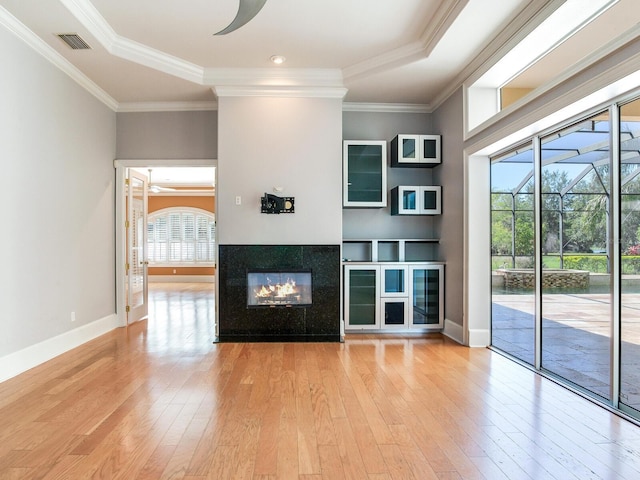 10504 Echo Lake Dr, Odessa, FL 33556 - unfurnished living room with light wood finished floors, ornamental molding, a multi sided fireplace, and baseboards