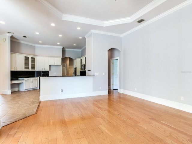 10504 Echo Lake Dr, Odessa, FL 33556 - unfurnished living room featuring arched walkways, light wood-type flooring, ornamental molding, recessed lighting, and baseboards