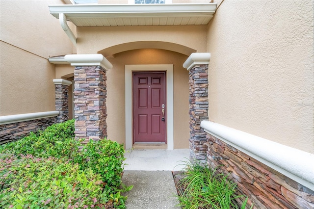 11839 Castine St, New Port Richey, FL 34654 - view of exterior entry featuring stone siding and stucco siding