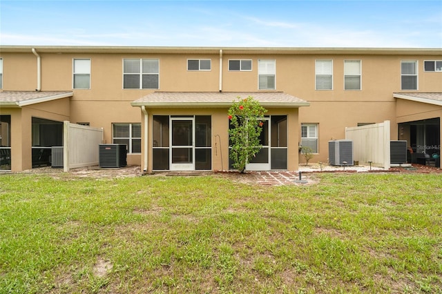11839 Castine St, New Port Richey, FL 34654 - back of property featuring central AC unit, stucco siding, a sunroom, and a yard