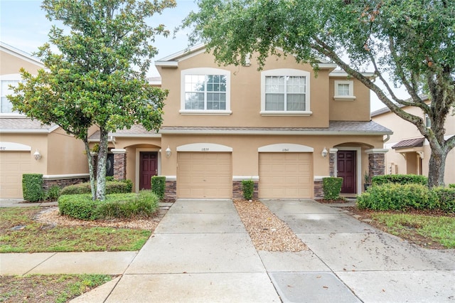 11839 Castine St, New Port Richey, FL 34654 - townhome / multi-family property featuring stucco siding, stone siding, driveway, and a garage